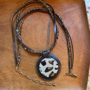 Enormous Chico’s medallion with a plastic cover on the faux hair medallion.